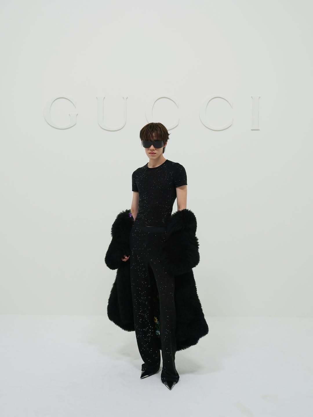 PP Krit in a dark glittering outfit with a fuller outer layer at Gucci