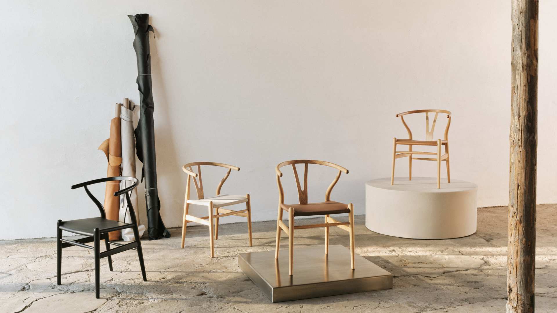 Four CH24 Wishbone Chairs in different finishes, including leather seats