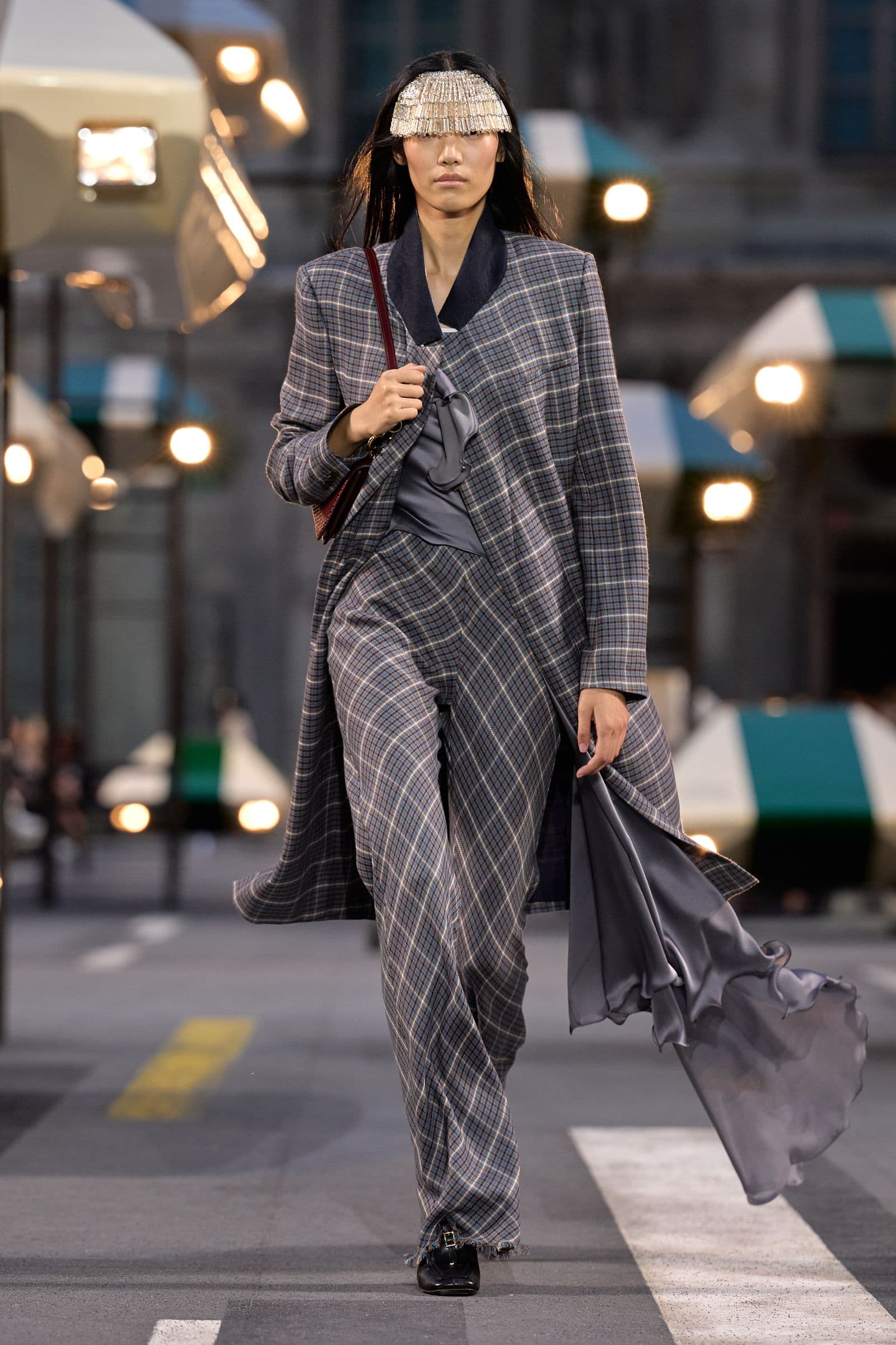 Look 31: a checked coat crossing the torso with a grey layer hanging at one side
