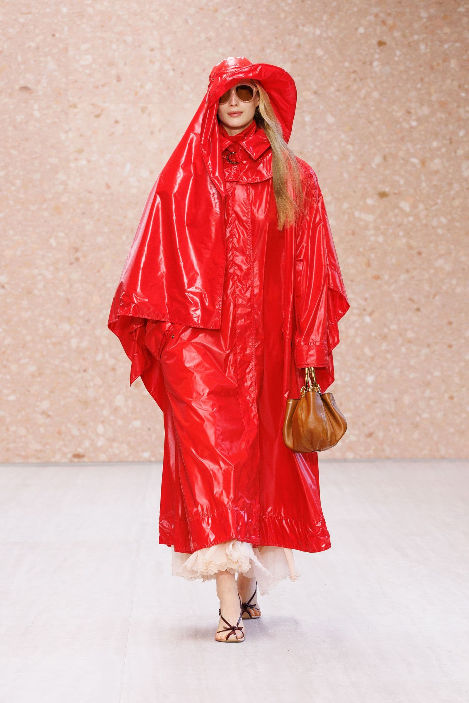 Chloé Spring 2027 look 32: red rain cape and wide-brim hat